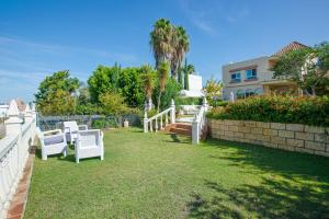 桑卢卡尔-德巴拉梅达4 bedrooms villa with sea view private pool and furnished terrace at Sanlucar de Barrameda 2 km away from the beach的一个带两把白色椅子和围栏的院子