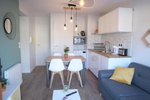 昂古莱姆Appart T2 avec terrasse, parking et wifi的厨房以及带桌子和沙发的客厅。