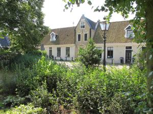 赫劳De Thuiskamer in Grou als B&B of Vakantiehuis的前面有路灯的房子