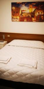 维罗纳Il Glicine的一张白色的床,上面有两条白色毛巾