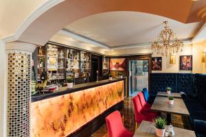 汉堡Hotel CULT Hamburg的餐厅设有酒吧,配有红色的椅子和桌子