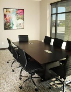 阿尔图纳Hyatt Place Altoona/Des Moines的一间会议室,配有一张黑色的大桌子和椅子