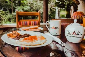危地马拉危地马拉优克斯拉比尔生态套房酒店的一张桌子,上面放着两盘早餐食品和一杯