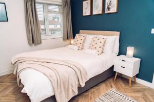 科尔切斯特Caroline Court - 1 Bedroom Apartment的一间卧室设有一张蓝色墙壁的大床