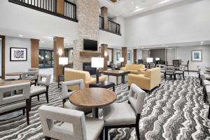 尔湾Staybridge Suites Irvine - John Wayne Airport, an IHG Hotel的大堂设有桌椅和等候室