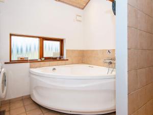 托斯明德7 person holiday home in Ulfborg的带窗户的浴室内的白色大浴缸