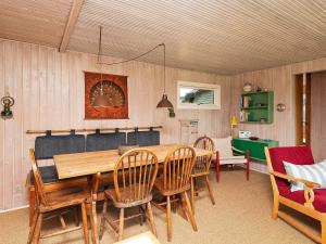 森讷维Two-Bedroom Holiday home in Ringkøbing 9的一间带木桌和椅子的用餐室