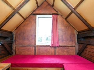 森讷维Two-Bedroom Holiday home in Ringkøbing 9的窗户客房内的一张红色的床