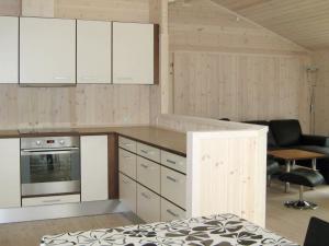 Engesvang6 person holiday home in Silkeborg的一间带白色橱柜的厨房和一间客厅