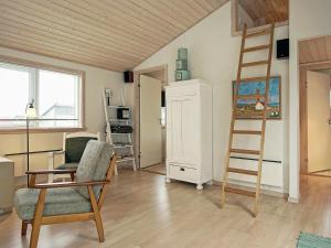 古兹耶姆4 person holiday home in Gudhjem的一间带梯子和椅子的客厅