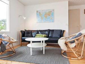 瓦伊厄斯斯特兰德4 person holiday home in Vejers Strand的客厅配有黑色沙发和桌子