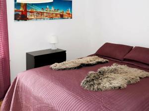 拉霍尔姆Apartment LAHOLM的紫色被子和毛绒毯子的床