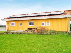 诺德堡8 person holiday home in Nordborg的黄色的房子,上面有太阳能电池板
