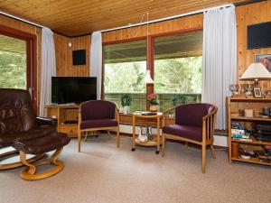 博利尔马克6 person holiday home in R m的客厅配有桌椅和电视。
