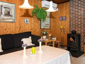 博利尔马克6 person holiday home in R m的客厅配有一张桌子、一张沙发和一个壁炉