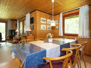 博利尔马克6 person holiday home in R m的一间配备有蓝色桌子和椅子的用餐室