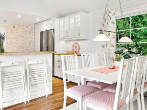 乌德瓦拉Holiday Home Herrestadsberg的白色的厨房配有白色的桌子和椅子