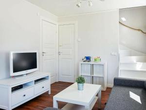 乌德瓦拉Holiday Home Herrestadsberg的一间客厅,在白色的橱柜上配有电视