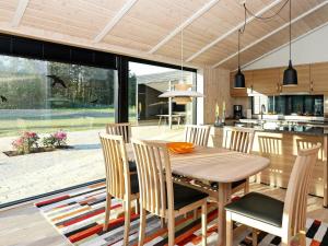 约灵8 person holiday home in Hj rring的厨房以及带木桌和椅子的用餐室。