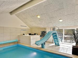 霍恩拜克14 person holiday home in Hornb k的一座房子里带滑梯的室内游泳池