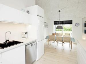 海默特Three-Bedroom Holiday home in Tarm 12的厨房配有白色橱柜和桌椅