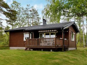 Stora LövnäsTwo-Bedroom Holiday home in Frändefors 1的小木屋,设有大甲板,位于庭院内