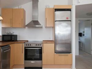 维泽桑讷6 person holiday home in Hvide Sande的厨房配有木制橱柜和不锈钢冰箱。