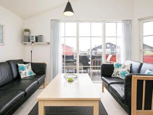 维泽桑讷6 person holiday home in Hvide Sande的客厅配有黑色真皮沙发和桌子