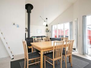 维泽桑讷6 person holiday home in Hvide Sande的一间带木桌和椅子的用餐室