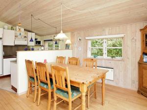 海默特6 person holiday home in Hemmet的厨房以及带木桌和椅子的用餐室。