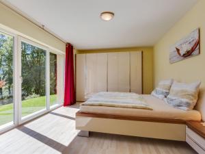 皮森多夫安格尔贝格公寓的一间卧室设有一张床和大窗户