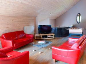 奥维法特Spacious Villa in Ovifat with Sauna的客厅配有红色家具和平面电视