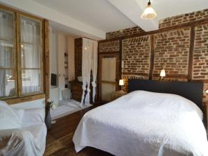 哈穆瓦尔Enchanting Cottage with Terrace Garden的卧室配有白色的床和砖墙