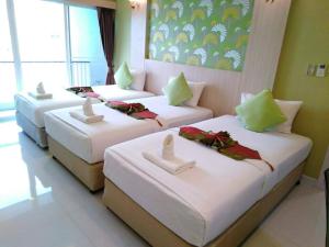 坤敬Family Hotel的酒店客房内的三张床,配有白色床单