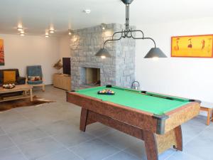 奥维法特Tasteful Holiday Home in Waimes with Sauna的客厅设有台球桌和壁炉。