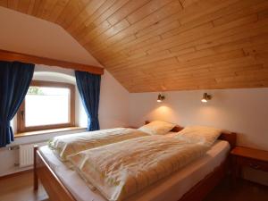 比特亨巴赫城堡花园度假屋的一间卧室设有一张带木制天花板的大床