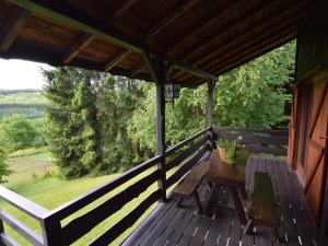 温瑟蒙特Pretty cottage Ardennes near the Valley of Lesse的木门廊,上面有桌子和长凳
