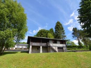 温瑟蒙特Pretty cottage Ardennes near the Valley of Lesse的山丘上树木背景的房子