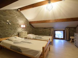 胡法利兹勒梅尔洛度假屋的一间卧室设有两张床和石墙