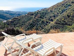 阿里纳斯Belvilla by OYO Casa Martijo的两把白色椅子坐在一个享有山景的庭院上