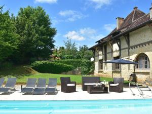 贝尔韦Sumptuous Mansion in Belves with Pool的一组椅子和一张桌子,旁边是游泳池