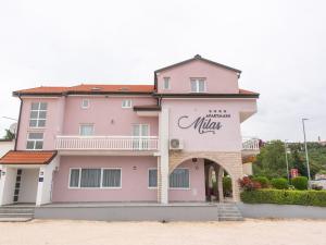 伊莫茨基Pretty Apartment in Imotski close to River的粉红色的建筑,上面有毛 ⁇ 标志