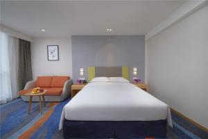 郑州郑州郑东智选假日酒店的酒店客房设有一张大床和一张沙发。