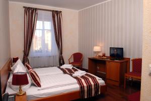 齐陶施瓦泽酒馆式酒店的配有一张床、一张书桌和一扇窗户的酒店客房