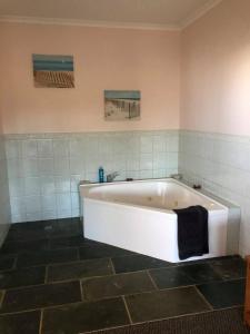 彭特派因Seaview Norfolk Island的浴室设有白色浴缸,铺着瓷砖。
