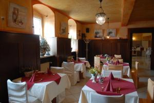 齐陶施瓦泽酒馆式酒店的一间设有白色桌子和红色餐巾的用餐室