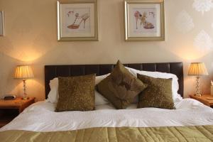 伊尔弗勒科姆科林代尔酒店的一间卧室配有一张带枕头的床,墙上挂有图片