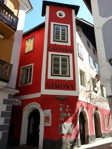 哈尔施塔特Gasthof Simony Hallstatt B&B的一座红色和白色的建筑,上面有标志