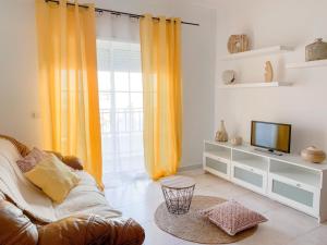 拉戈阿Apartamento T2 Carvoeiro-Lagoa preços acessíveis的带沙发和电视的客厅