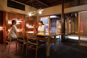 高冈市民家ホテル「金ノ三寸」(かねのさんずん）的坐在餐厅桌子上的两名妇女